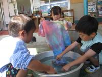 4歳児水で色付けしたTシャツを洗っています