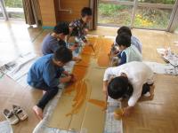 段ボールに友達と一緒に色を塗っています