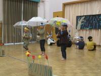 傘をさして踊っています
