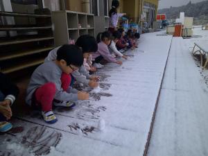 4歳児がテラスで雪遊びをしています