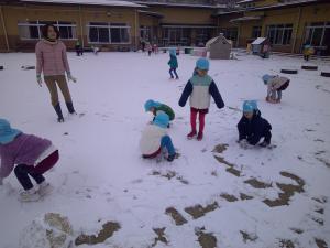 4歳児が雪を集めています