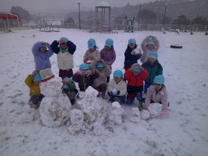 4歳児が雪だるまポーズをしています