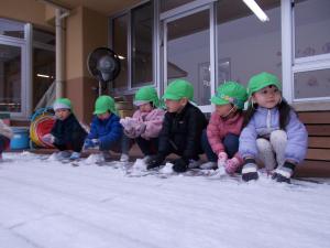 3歳児がテラスで雪を集めています