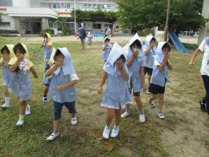 避難訓練で防災頭巾をかぶって避難しているところ