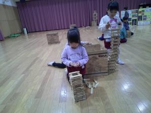 カプラを高く積み上げようとする4歳児