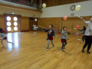 風船で羽根つきをする子ども達