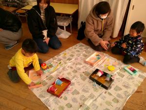 お家の人とおひなさまづくりをしている3歳児