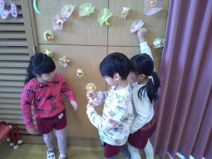 4歳児が友達と相談しながらお花を飾っています