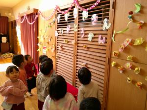 3歳児が飾った壁面をみんなで見ています