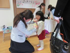 担任の先生に名札をつけてもらっています