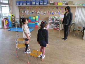 保育室で園長先生の話を聞いている子ども達