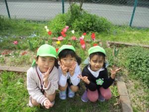 チューリップの前で集合写真をとる子ども