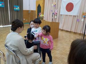 ペンダントをもらっている3歳児