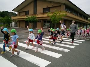 みんなで手を繋いで横断歩道を渡っています