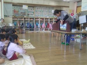 紙芝居を興味津々で見ています