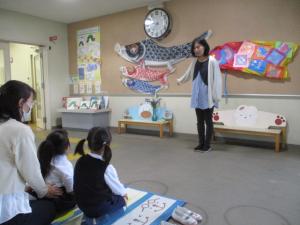 園長先生からこいのぼりの話を聞いている子ども達