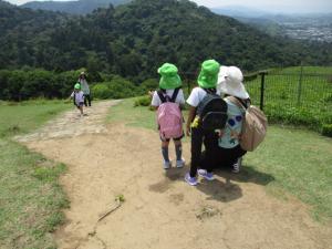 若草山を登っている友達を応援している子どもと先生