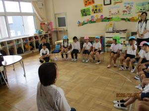 幼稚園の友達が先生の話を聞いている