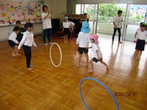 フープを転がして遊んでいる子ども