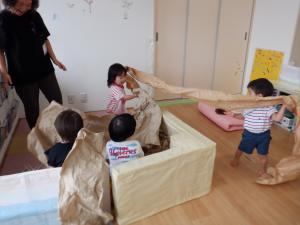 友達と大きな紙を引っ張りあっています