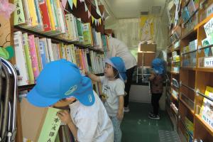 移動図書のバスの中で本を選ぶ子ども達