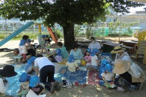 園庭で選んだ本を読む子ども達
