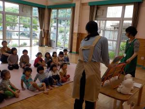 大型絵本を読み聞かせてもらう子ども達