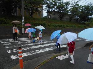 傘をさして歩いて行きました