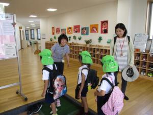 こども園の玄関で園長先生と話をしている子ども達