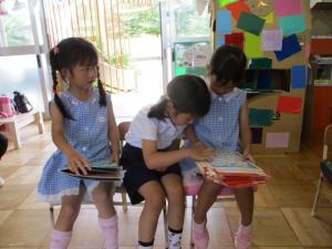 友達と絵本を読んでいる子ども