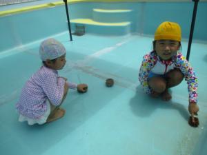 友達とプールを洗っている子ども