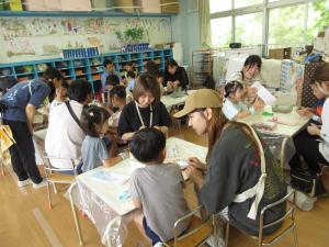 七夕の短冊をかく５歳児と保護者