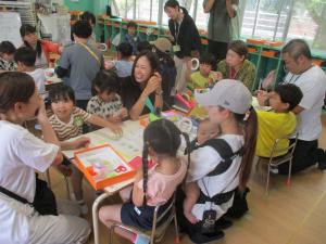 ４歳児と保護者が笑顔で笹飾りをしている