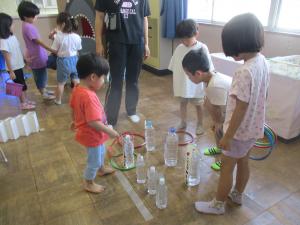 輪投げをする子どもと見守る子ども