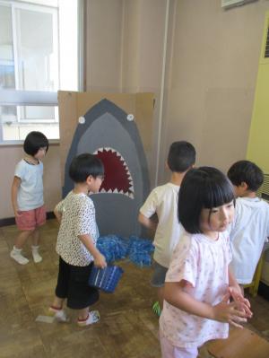 サメの口をめがけてボールを投げる子ども