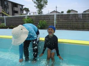 プールで水しぶきを浴びている子ども