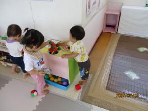 穴に入るかなといろいろ入れている子ども