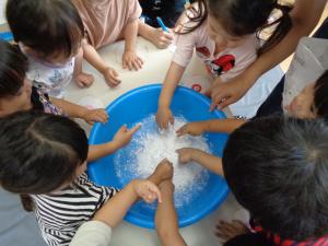 タライで感触遊びをする子ども