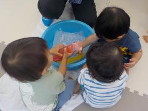 冷たい氷で感触遊びをする子ども