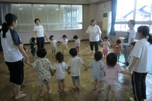 手をつないで輪になって遊ぶ子ども