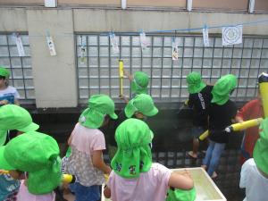 4歳児水鉄砲で的あてをする様子