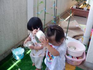 容器に水を入れて頭からかけています。