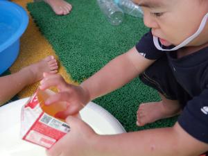 牛乳パックから色のついた氷を出そうとしています