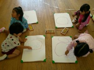 3歳児夏の思い出の絵をかいています