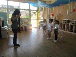 保育室で園長先生の話を聞いている子ども達