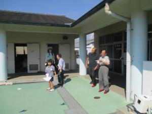 外で飛行機を飛ばしている子どもと地域の方