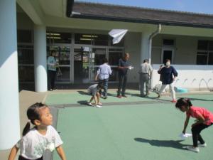 外で飛行機を飛ばしている子ども