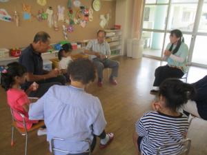 地域の方と子ども達がヤクルトを飲んで休憩している。
