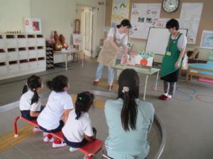 図書館の方のお話を聞いている子どもと先生