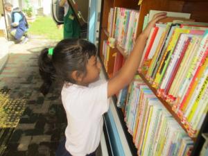 移動図書の絵本を選んでいる子ども